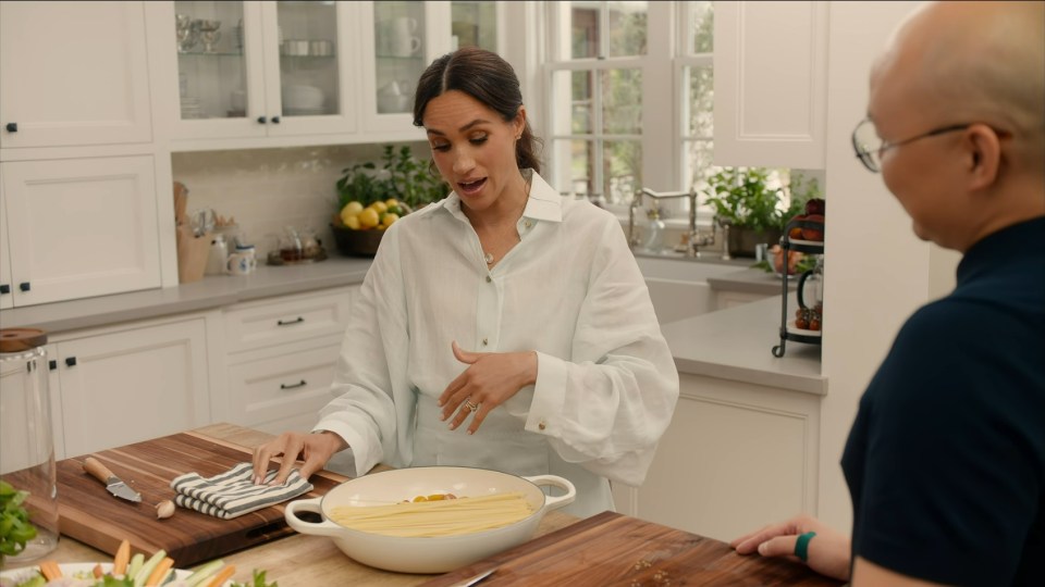 Meghan Markle preparing pasta in a kitchen with Daniel Martin.