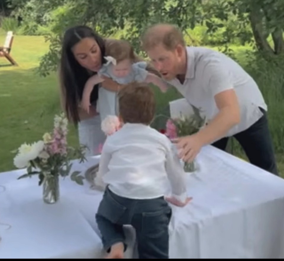 Harry, Meghan, and their children at an outdoor table.