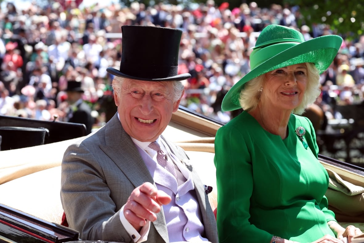A man and woman in formalwear ride in a carriage