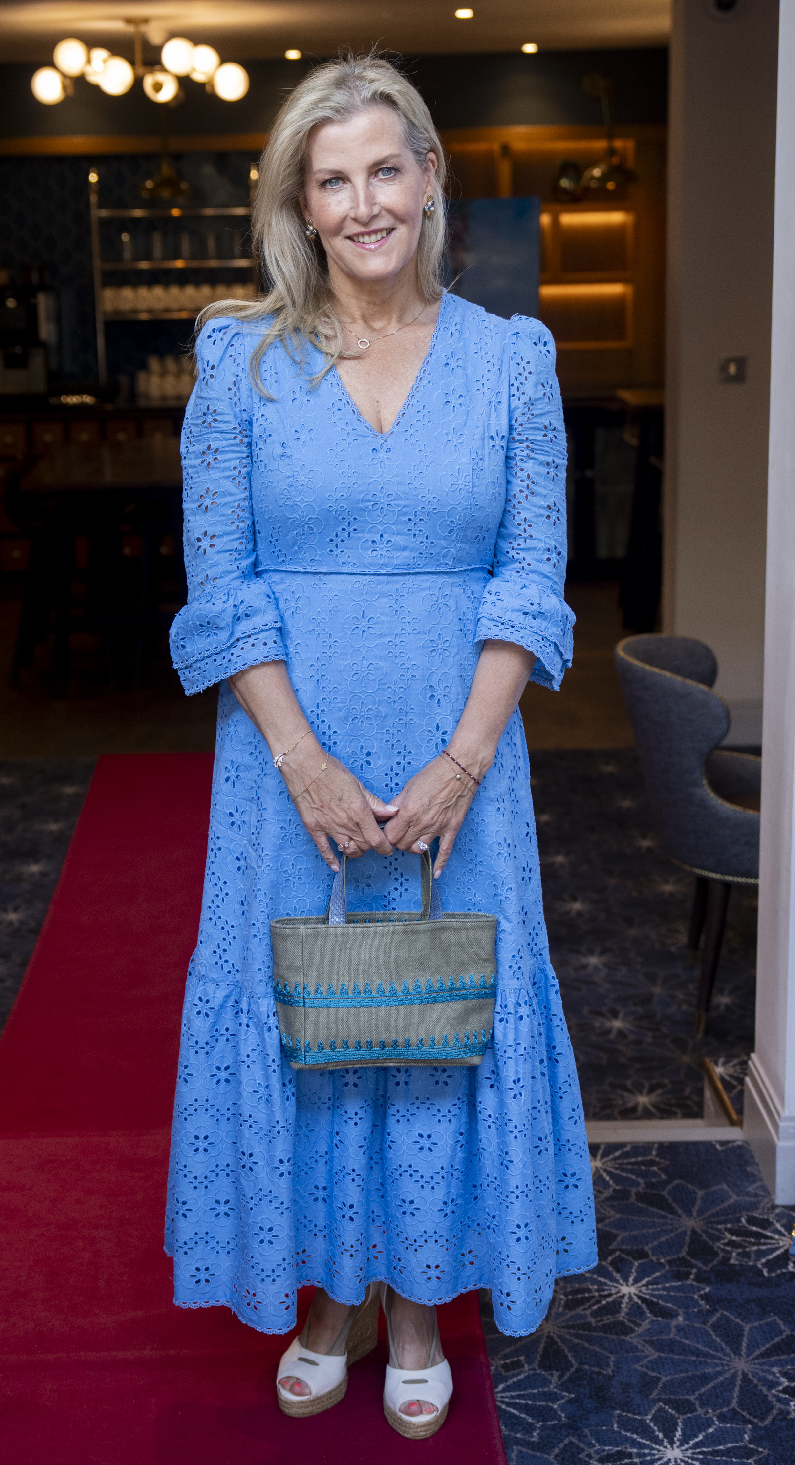Duchess Sophie wearing a blue dress holding a straw bag