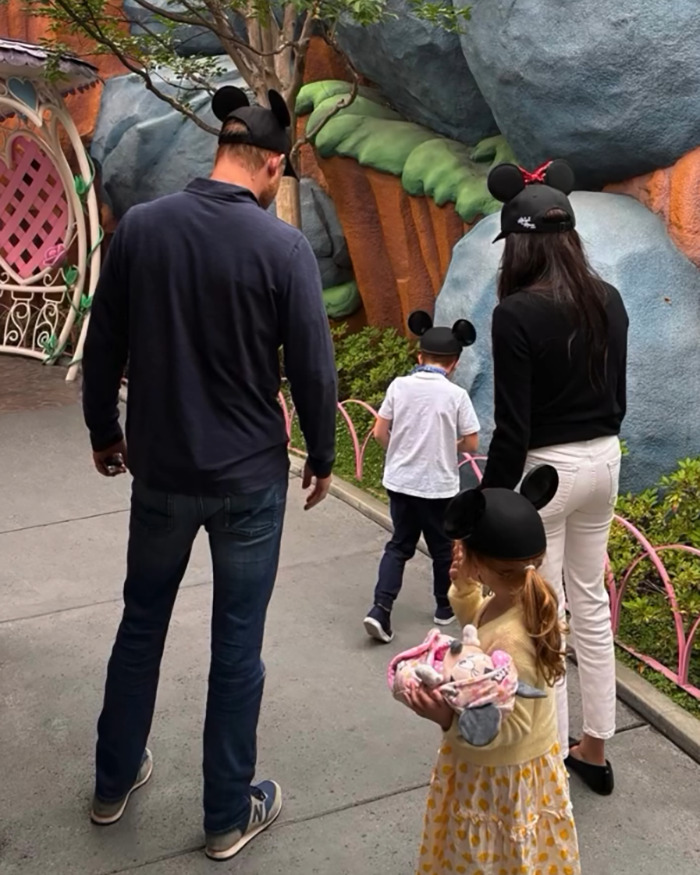 Family wearing mouse ear hats at a theme park, highlighting Meghan Markle accused of treating her kids like accessories. Family wearing mouse ear hats at a theme park, highlighting Meghan Markle accused of treating her kids like accessories.