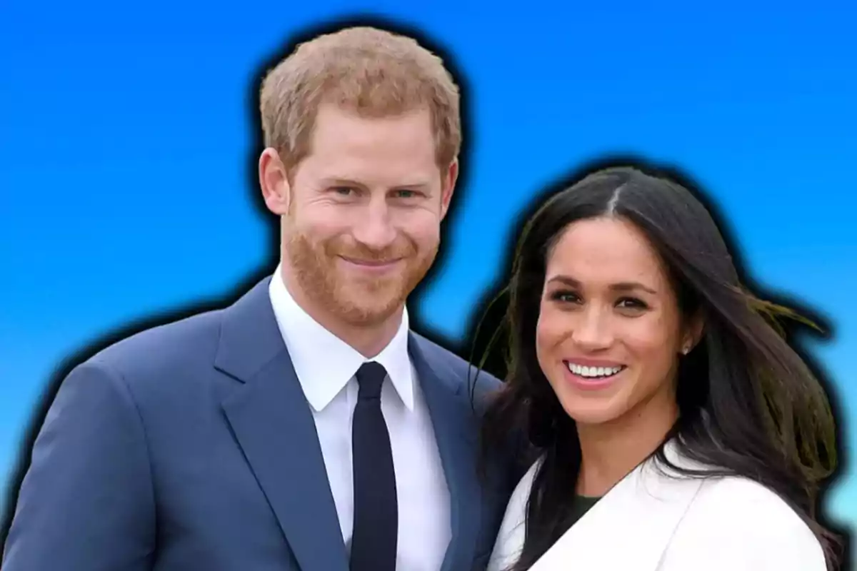 A smiling couple posing in front of a blue background.
