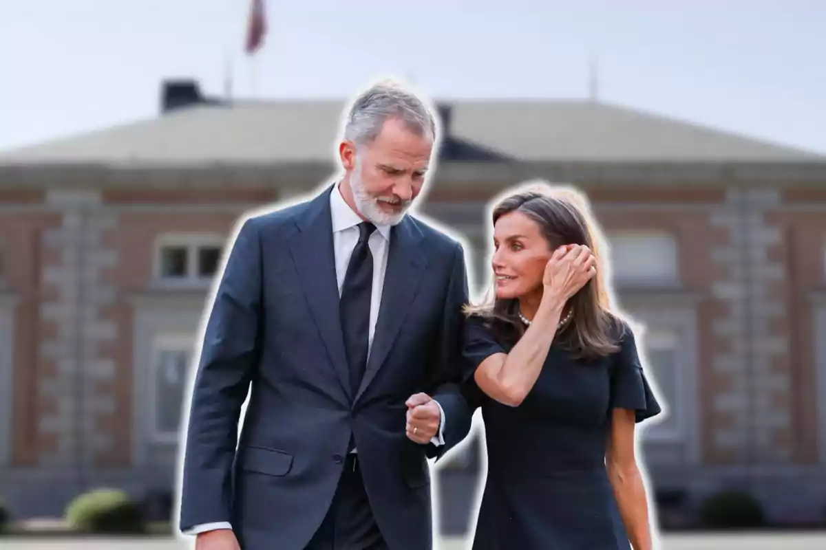 A couple walking in front of an elegant building.