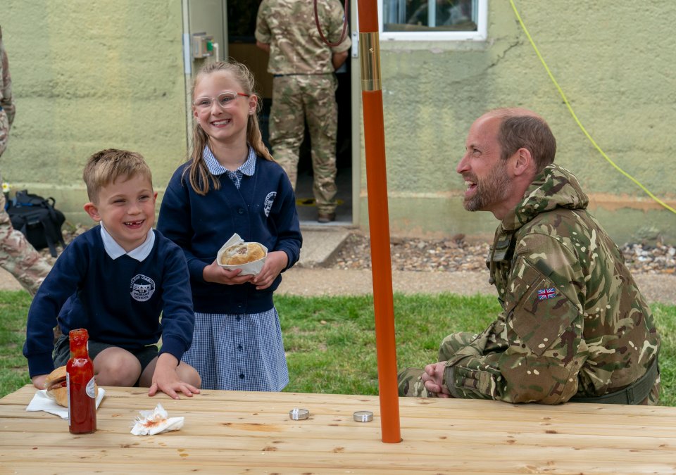 Prince William speaking with children at an event.