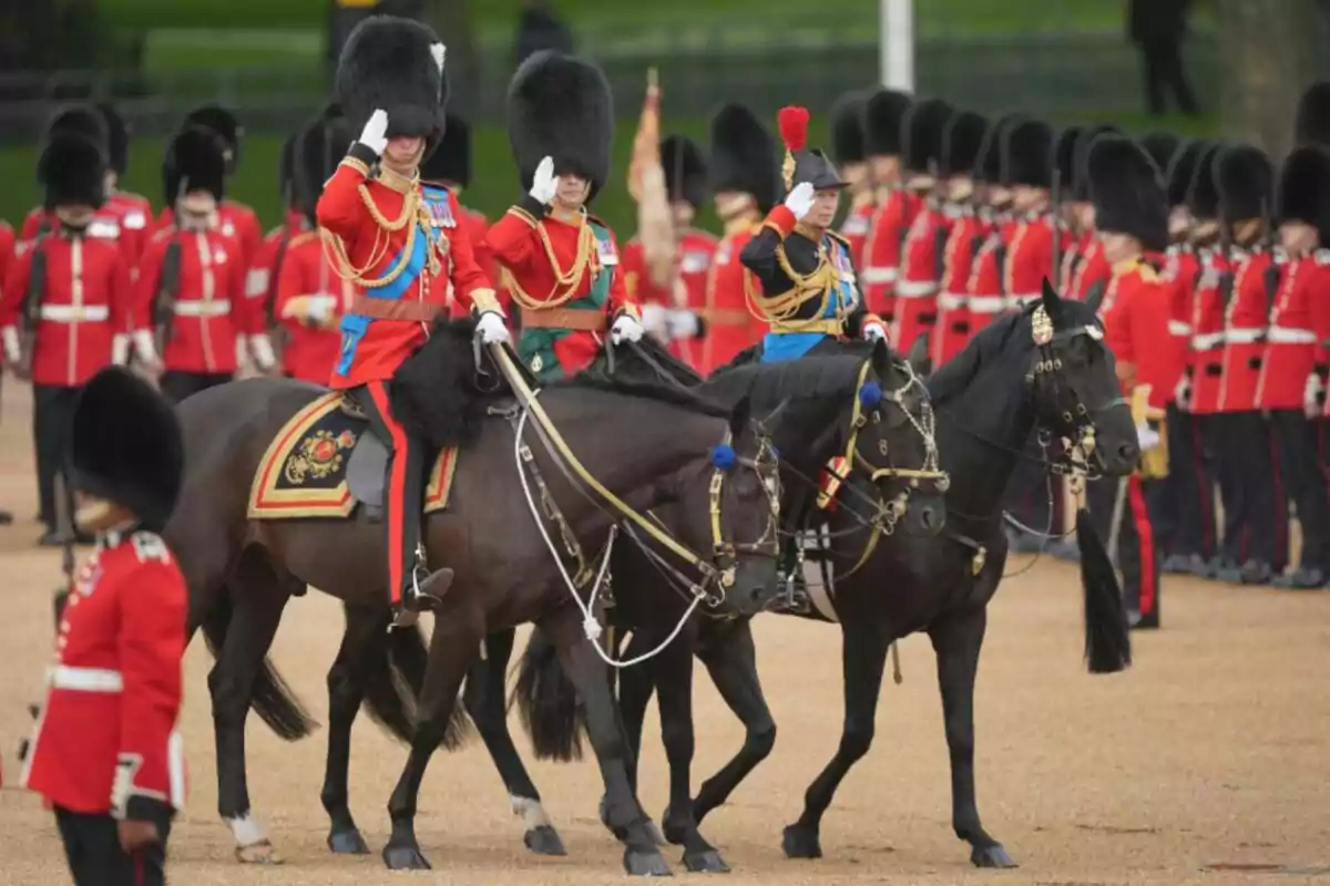 Military parade with uniformed British soldiers riding horses and saluting while other soldiers march in formation in the background Military parade with uniformed British soldiers riding horses and saluting while other soldiers march in formation in the background