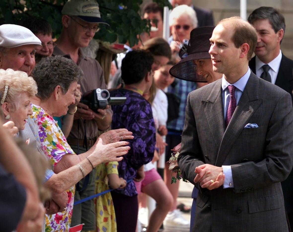 A person walks along a line of people.
