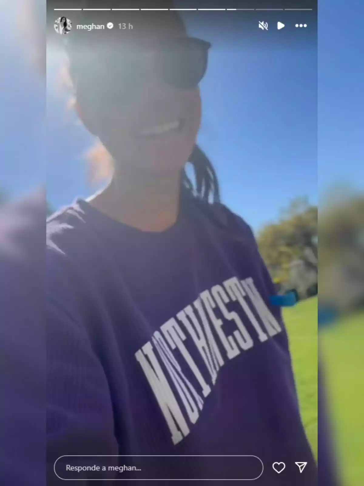 Meghan Markle in sunglasses and a purple sweatjersey with the word Meghan Markle in sunglasses and a purple sweatjersey with the word