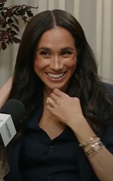Meghan Markle smiling during a podcast interview.