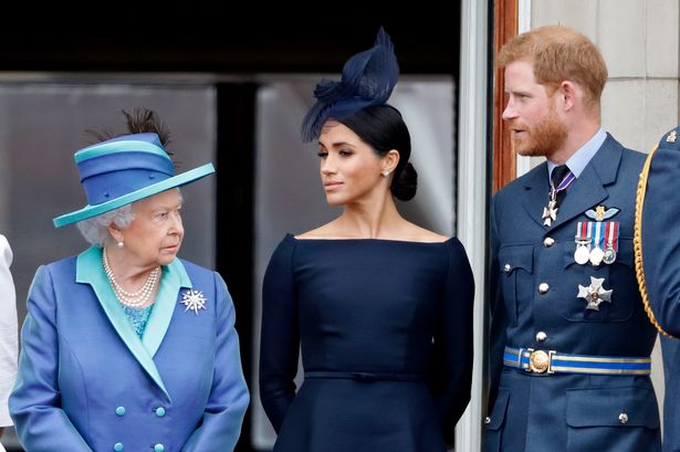 Queen Elizabeth II, Meghan, Duchess of Sussex and Prince Harry, Duke of Sussex watch a flypast to mark the centenary of the Royal Air Force from the balcony of Buckingham Palace on July 10, 2018 in London