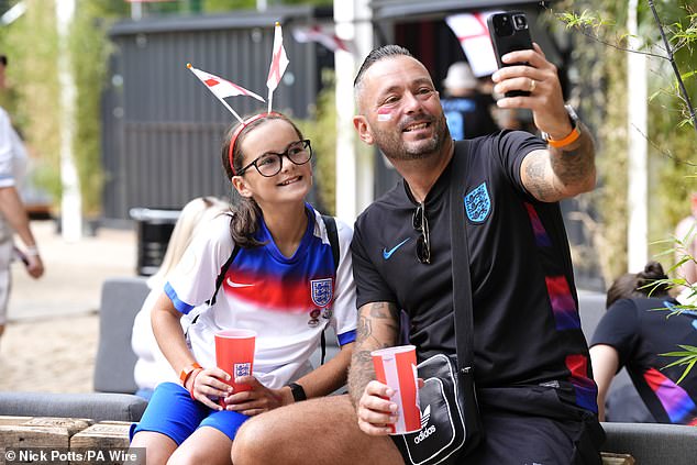 Fans take photographs in the fan zone ahead of the UEFA Women's Euro 2025 final as they sip cool drinks ahead of the game