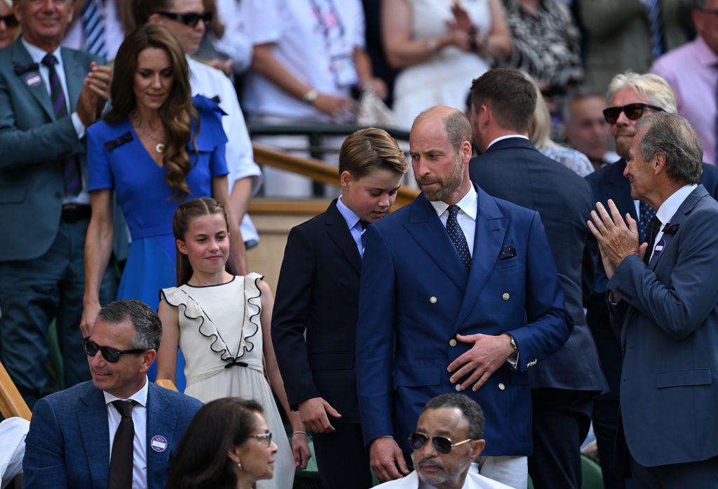 Prince William biting his lip with Prince George in the background
