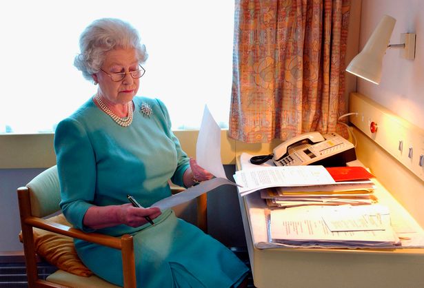 Queen Elizabeth II works at her desk on the Royal Train in May of 2002.