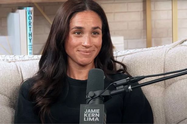Meghan Markle on a podcast wearing a black t-shirt and bare faced with no makeup on 