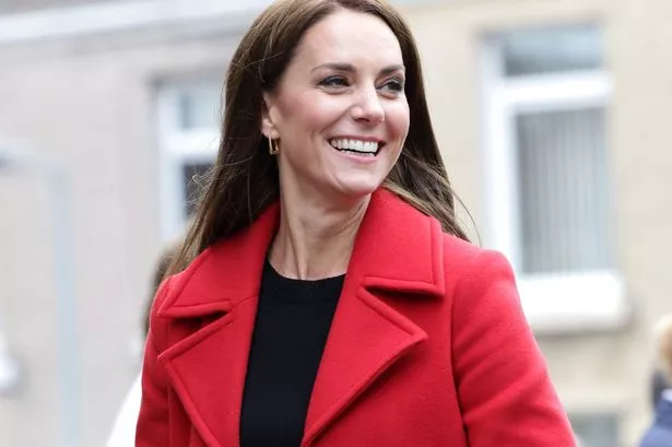 Kate Middleton wearing a red coat, smiling