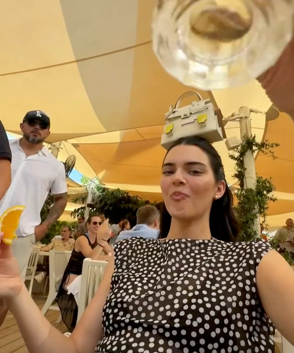 After drinking the shot at Loulou’s beach club on Pampelonne Beach, Kendall held her arms out as the handbag, which was recently sold for $74,500, sat motionless on her dark tresses. Devon Carlson/Instagram