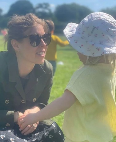 Princess Beatrice holding her daughter's hand in the sunshine 