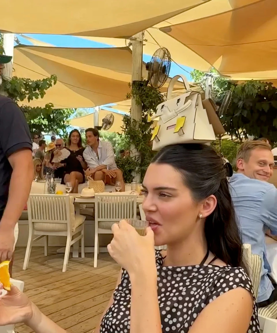 Kendall Jenner balanced a pricey handbag on her head as she took a shot of alcohol, days after attending the “tone-deaf” wedding of Jeff Bezos and Lauren Sánchez. Devon Carlson/Instagram