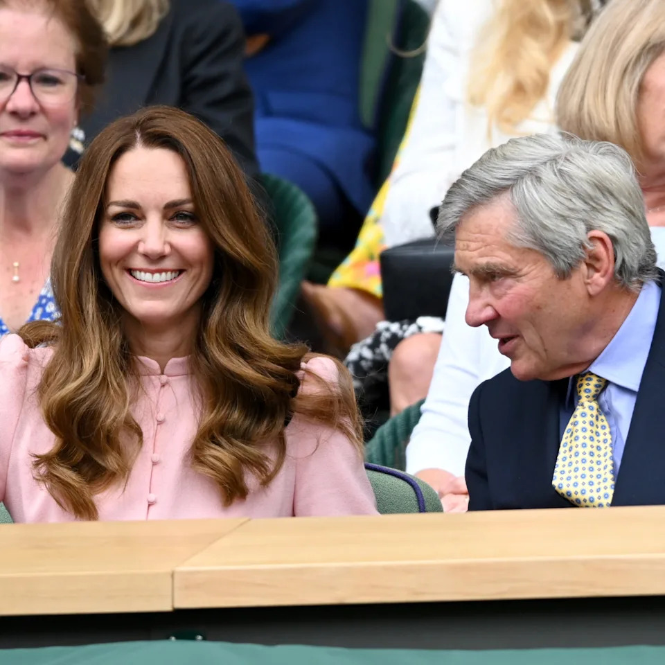  Kate Middleton wears a pink shirt dress and has long brown wavy hair attending Wimbledon with her dad Michael Middleton. 
