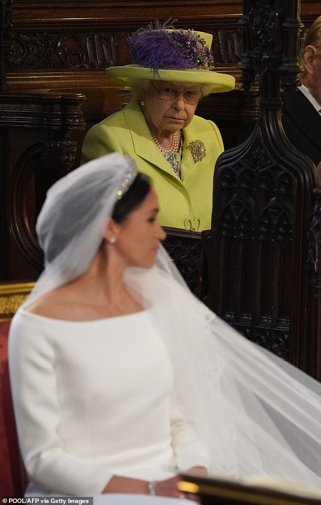 The Queen looks towards Meghan on the Duchess's wedding day. The late Queen reportedly thought her dress was 'too white' for a divorcee