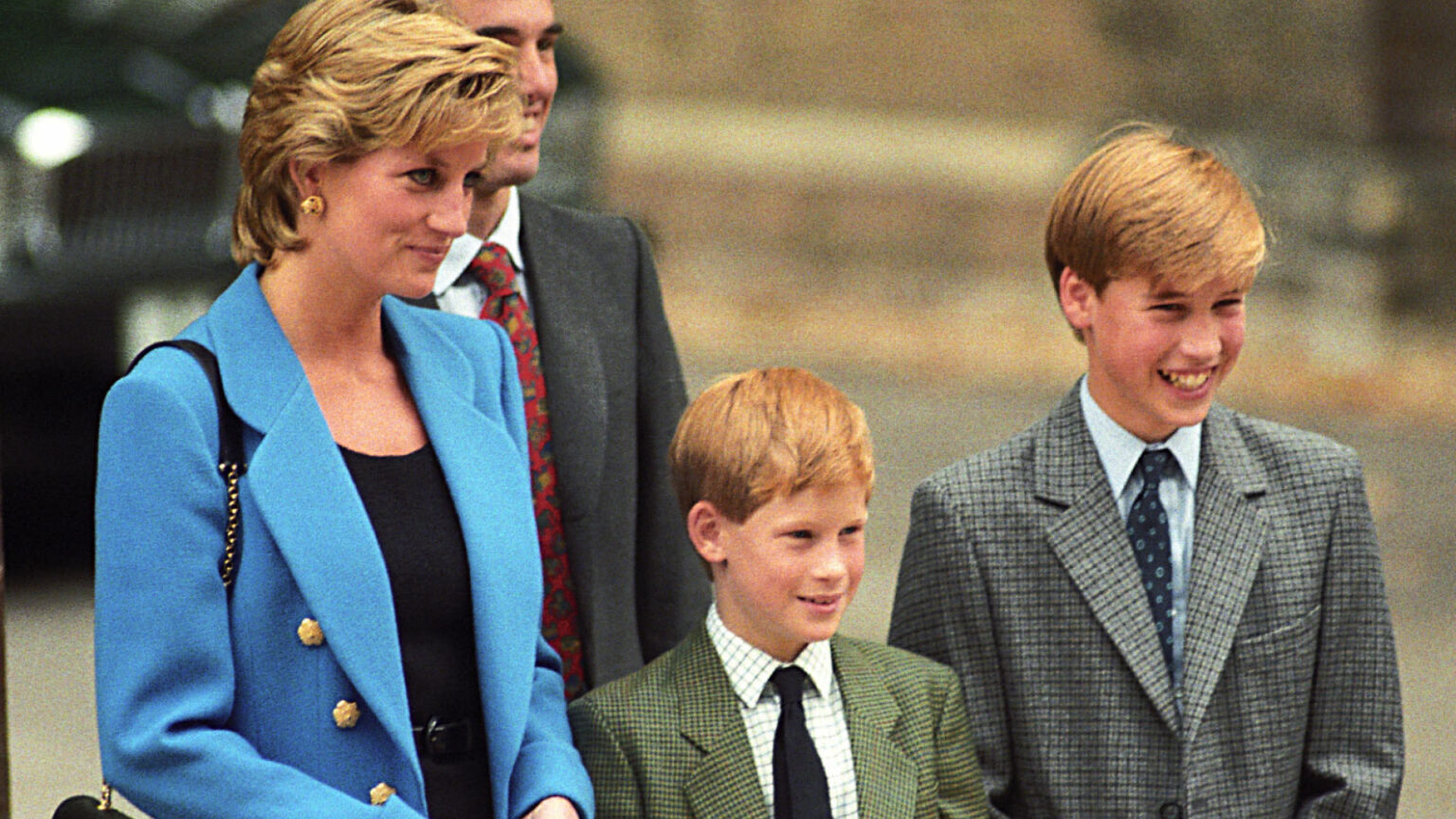 Why Princess Diana Didn’t Want Prince Harry to Attend Eton Princess Diana wears a blue suit jacket while posing with young sons Prince Harry and Prince William who wear gray suits during a visit to Eton school