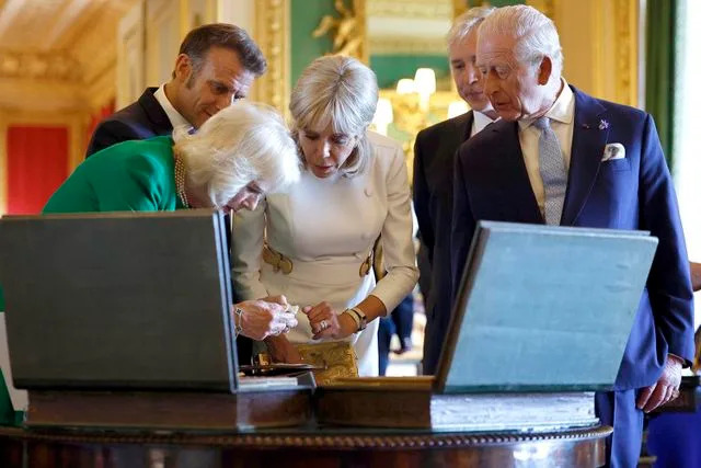 Benjamin Cremel - WPA Pool/Getty French President Emmanuel Macron and wife Brigitte view an exhibition of art from the Royal Collection alongside King Charles and Queen Camilla on July 8, 2025
