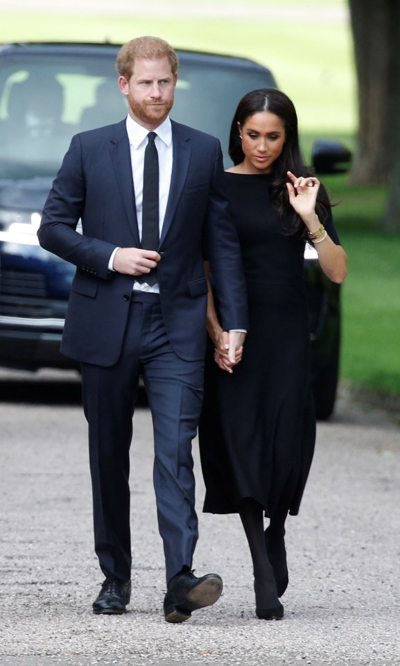 Prince Harry and Meghan, the Duchess of Sussex, walking hand-in-hand outside Windsor Castle.