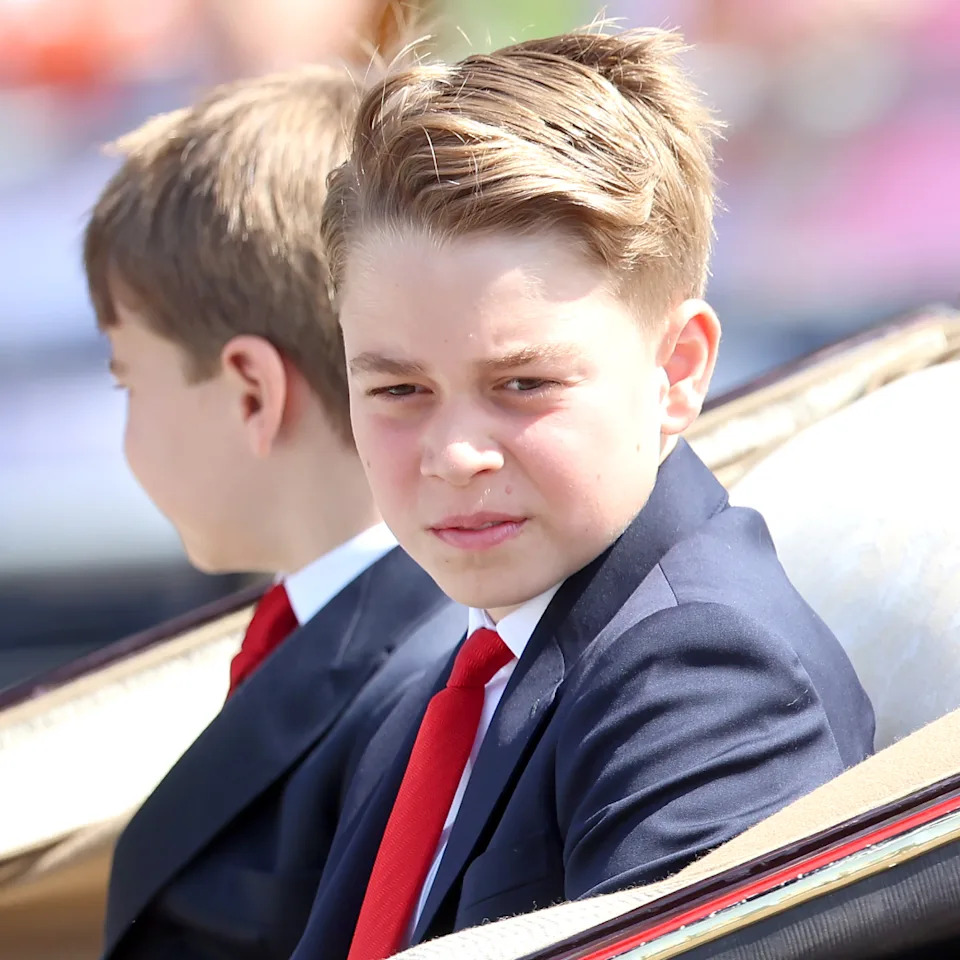 Prince George wears a navy suit and red tie to attend Trooping the Colour 2025.