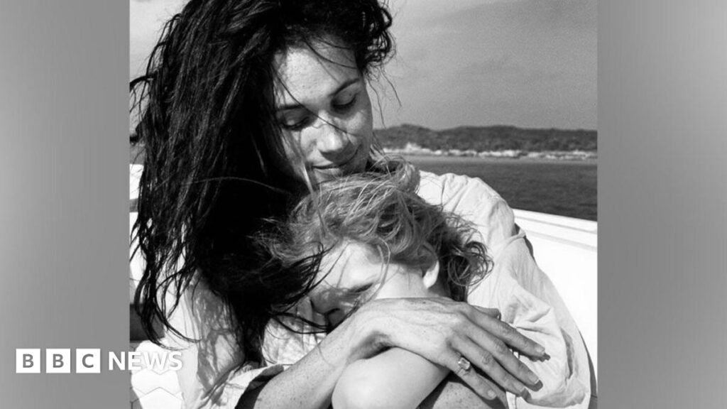 Meghan holding Lilibet in her arms