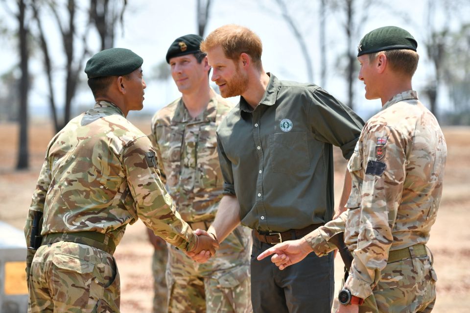 Prince Harry shaking hands with British soldiers at a memorial site in Malawi.