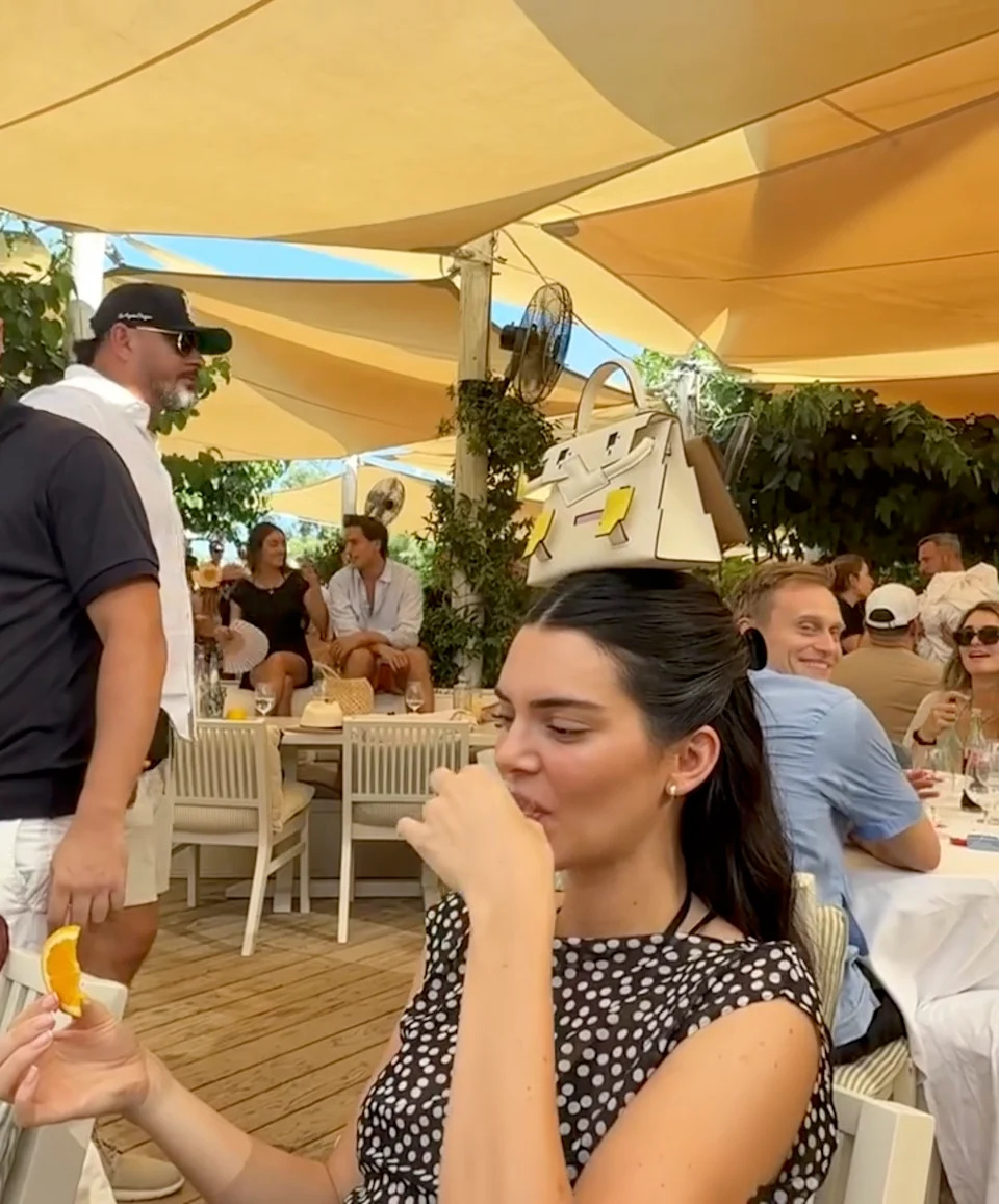 While vacationing in Saint-Tropez, France, with her sister Kylie Jenner and their friends, the 818 Tequila founder placed a limited-edition Hermès Kelly Doll bag on the top of her head as she downed a shot of clear liquor. Devon Carlson/Instagram
