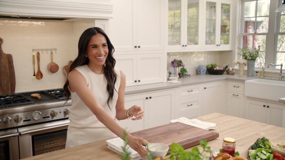 Meghan, Duchess of Sussex, smiling in a kitchen.
