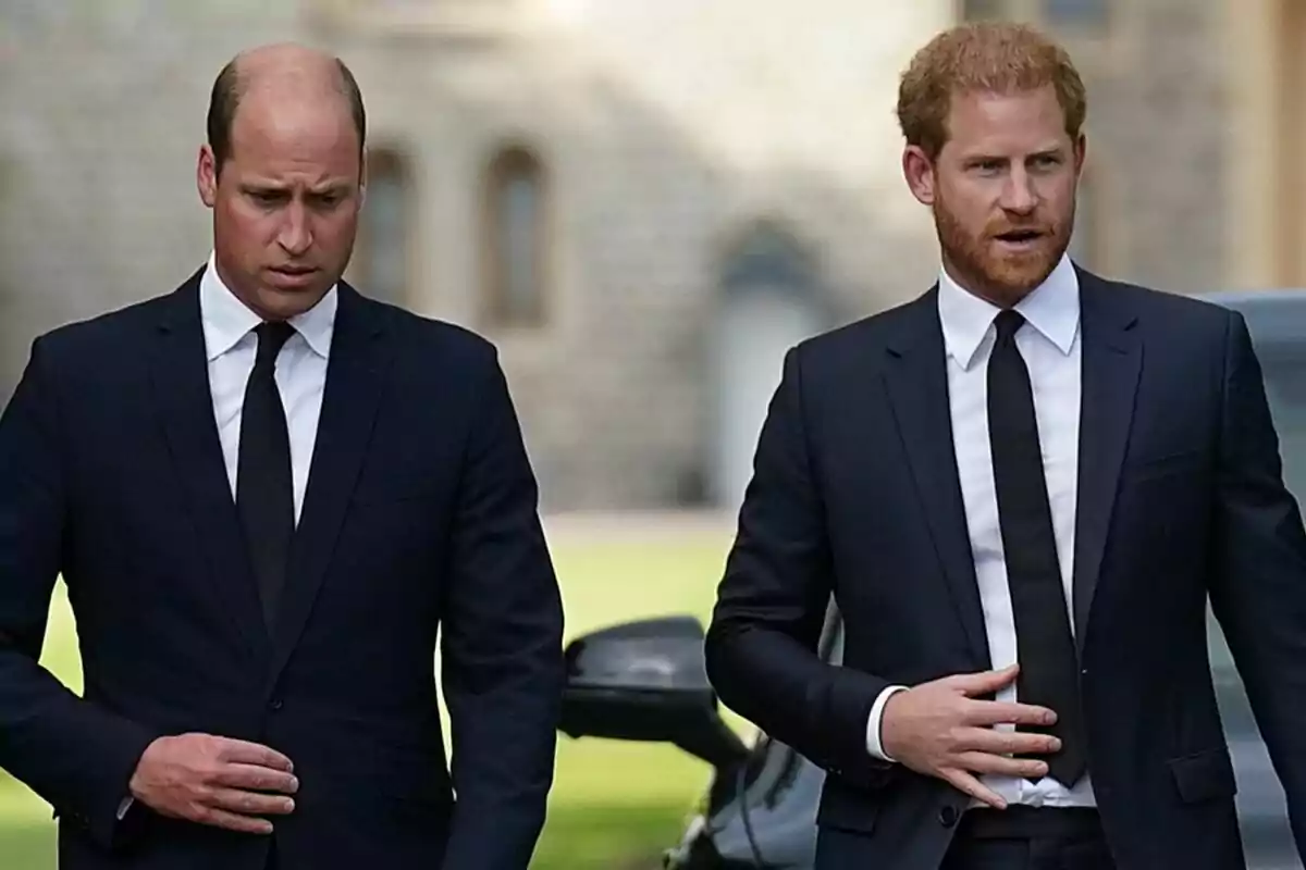 Two men dressed in dark suits and black ties walking outdoors.