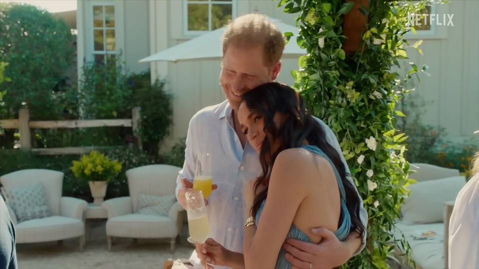 Meghan Markle and Prince Harry embracing outdoors.