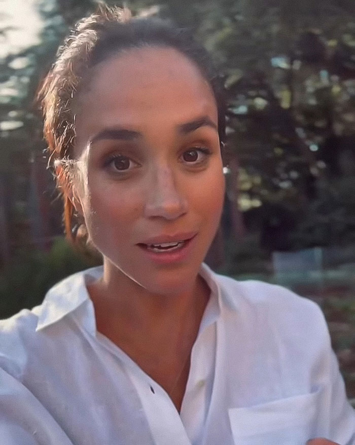 Meghan Markle in a white shirt outdoors with trees in the background, linked to fruit-picking photo accusations. Meghan Markle in a white shirt outdoors with trees in the background, linked to fruit-picking photo accusations.