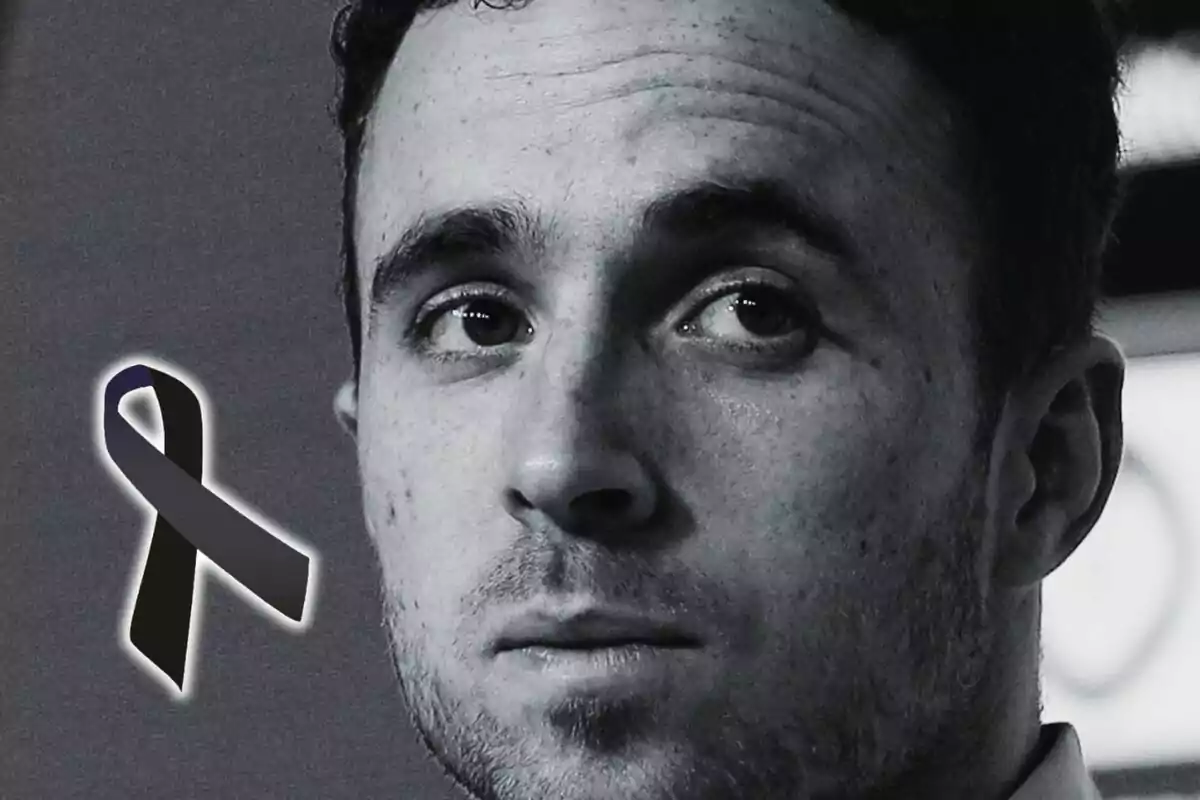 Black and white portrait of Diogo Jota with a serious expression and a black mourning ribbon on the left.