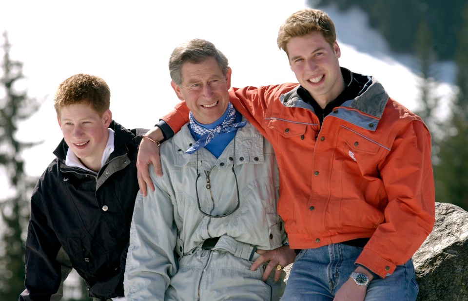 Prince Charles smiling with Princes William and Harry on a skiing holiday.