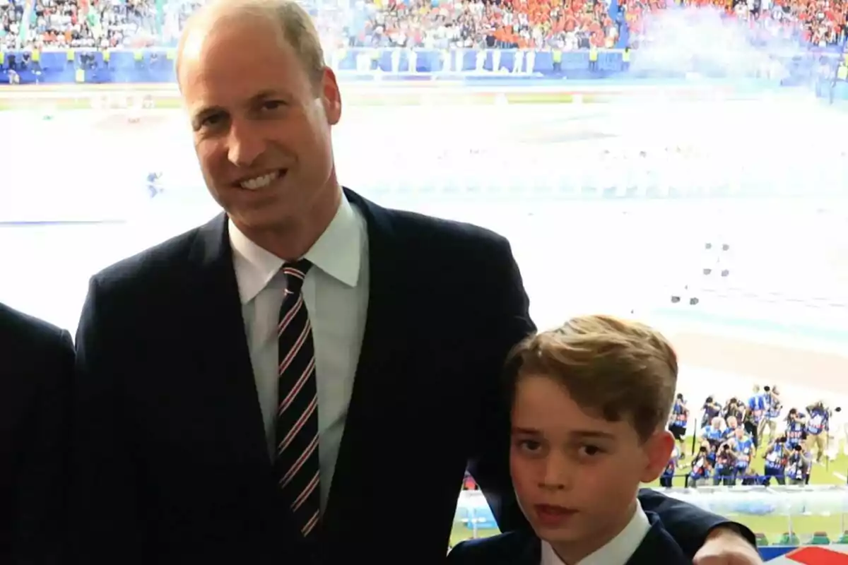 Image of Prince George and Prince William in a stadium full of spectators.