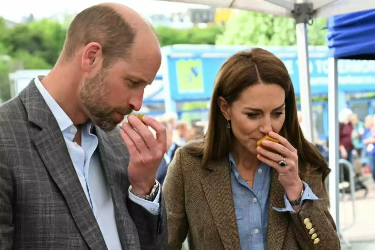 Prince William and Kate Middleton are smelling fruits at an outdoor event. Prince William and Kate Middleton are smelling fruits at an outdoor event.