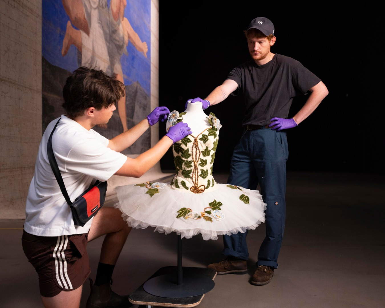Staff examines the ballet costume of the Forest Glade Fairy, in front of Picasso's Le Train Bleu