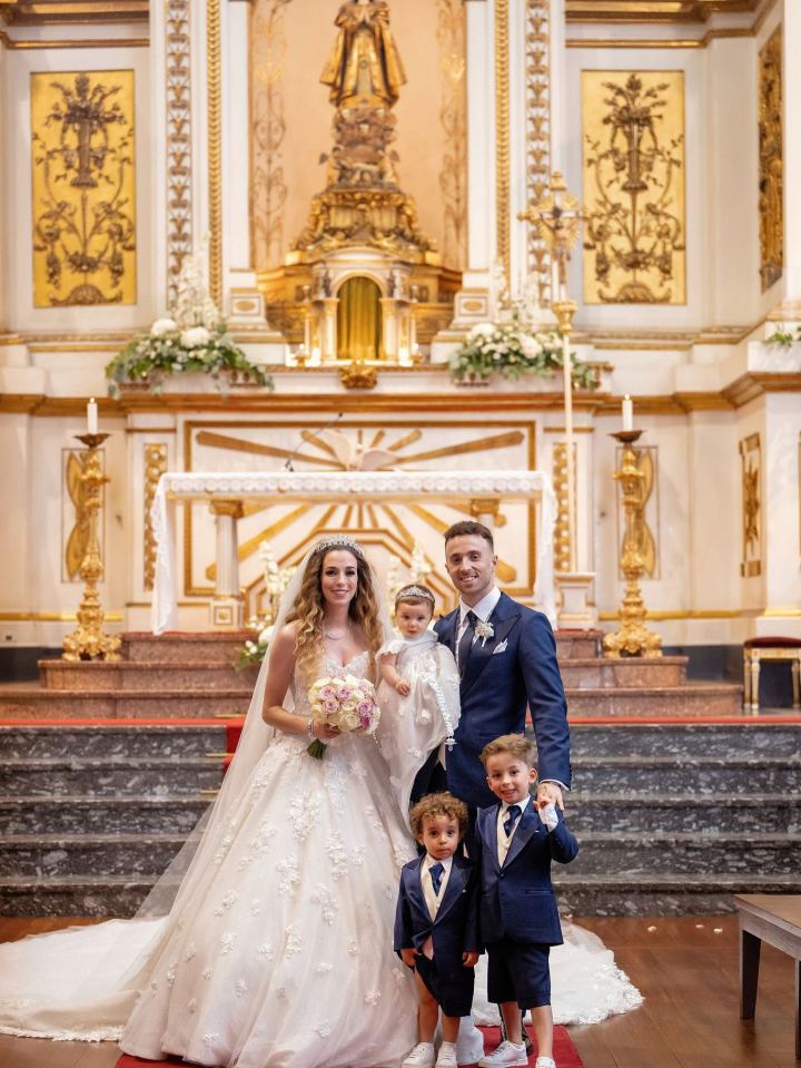Bride and groom with their children in a church.