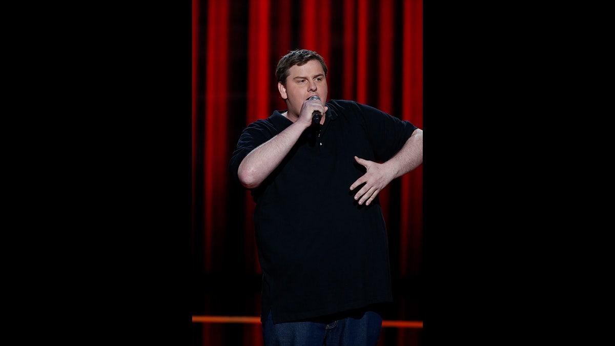 Tim Dillon on stage talking into microphone