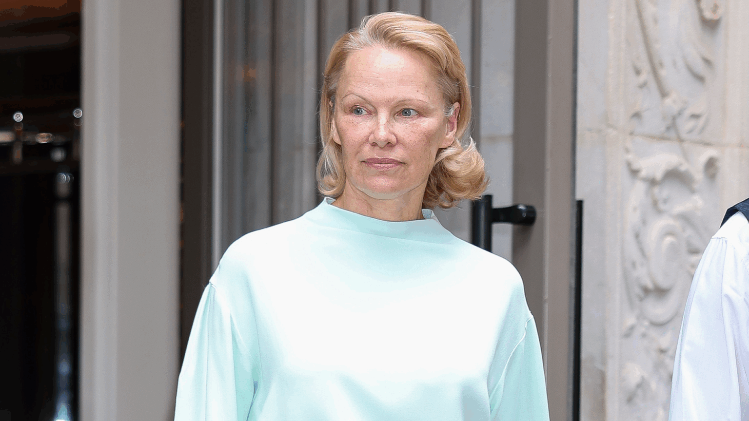 Pamela Anderson paired a monochromatic skirt set with Strathberry's Mosaic Bag.