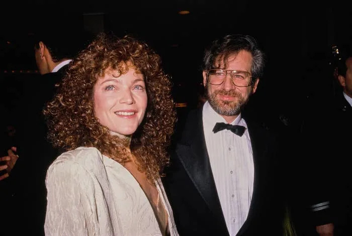 I don't know who they are, but the man is in a tuxedo with a bow tie, and the woman is in a textured, elegant jacket on what appears to be a red carpet