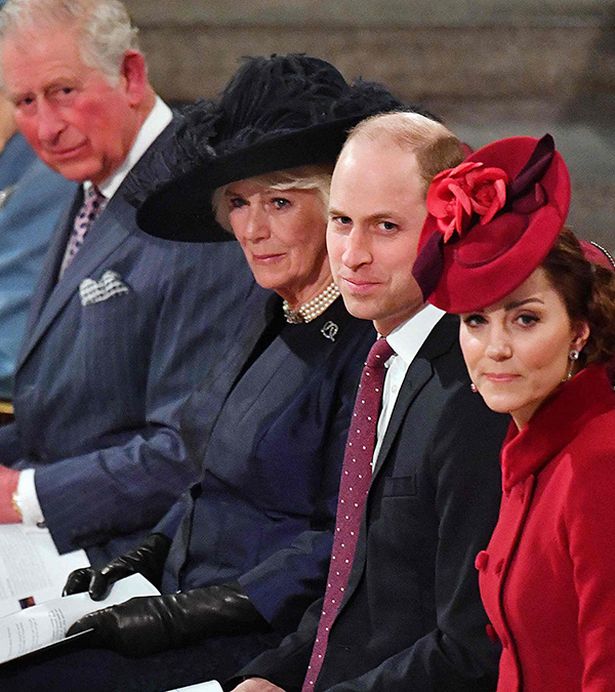 Charles, Camilla, William and Kate look together at a doorway