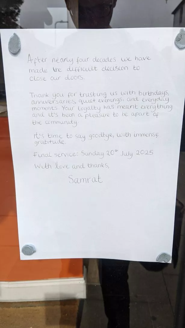 The handwritten message left on the front window of the restaurant
