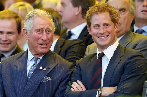 King Charles and Prince Harry laughing together wearing suits