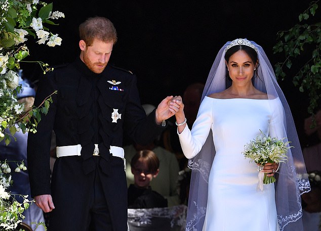 TOPSHOT - Britain's Prince Harry, Duke of Sussex and his wife Meghan, Duchess of Sussex emerge from the West Door of St George's Chapel, Windsor Castle, in Windsor, on May 19, 2018 after their wedding ceremony. (Photo by Ben STANSALL / POOL / AFP) (Photo by BEN STANSALL/POOL/AFP via Getty Images)
