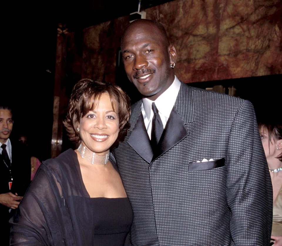 I don’t know who these people are. A man in a checkered suit and a woman in an elegant dress pose together at an event