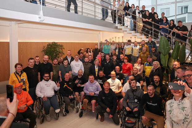 Prince Harry poses with people who were wounded in war with Russia