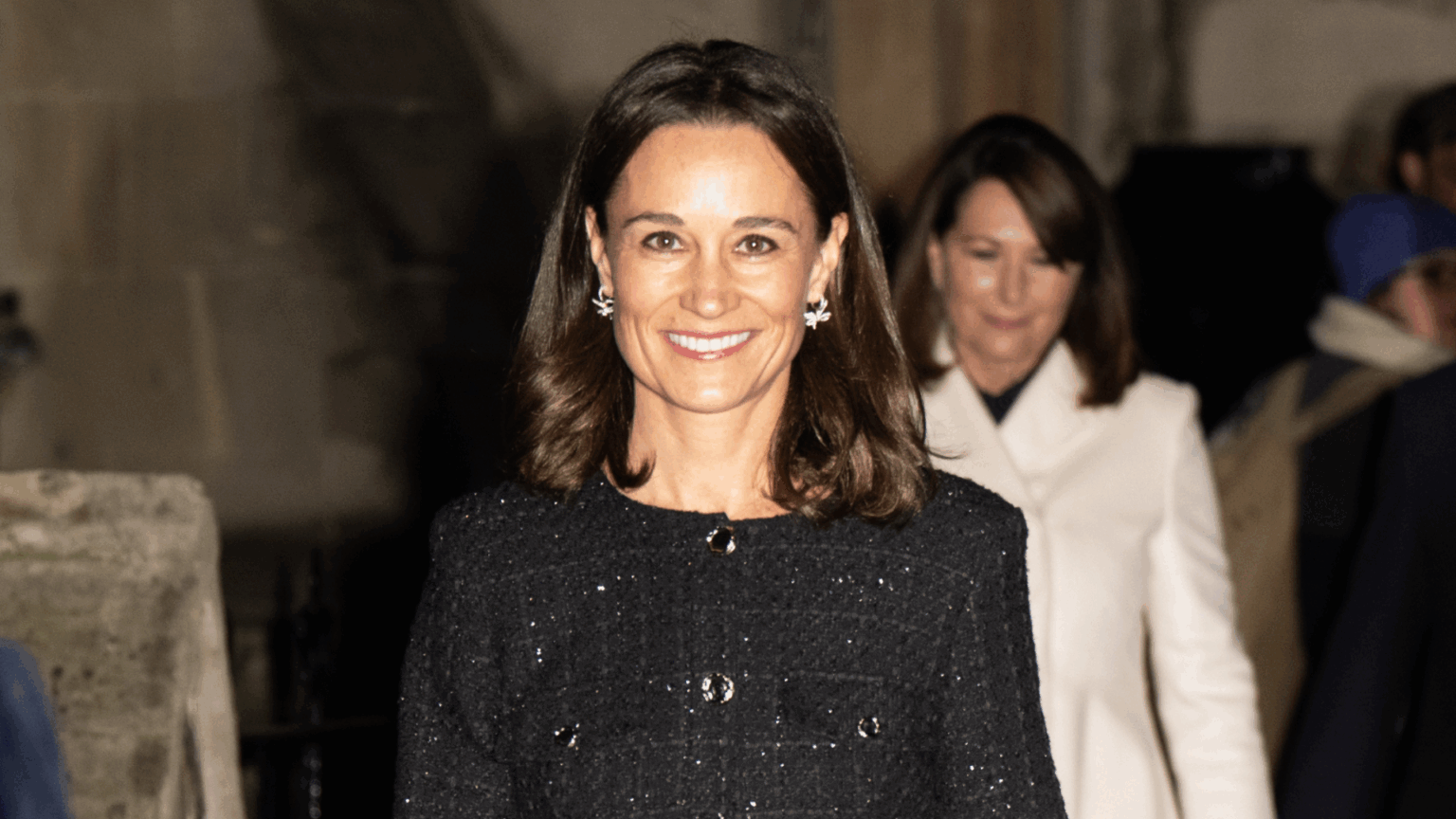 Pippa Middleton wearing a sparkly black coat and smilig